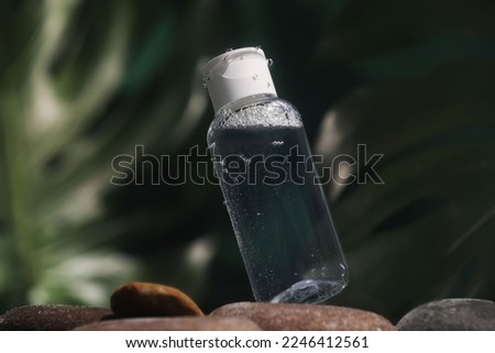 Bottle of micellar water in liquid on blurred background