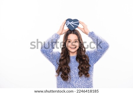 Teen celebrating birthday. Christmas teenager girl with gift, x-mas, happiness concept. Happy girl in winter sweater holding gift box. Isolated stodio background.