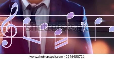 Man with pen writing staff with music notes and symbols on color background, closeup. Banner design