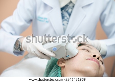 Beautician procedure by electric device,Ultrasound therapy treatment for skin tightening in aesthetic clinic. Royalty-Free Stock Photo #2246451939
