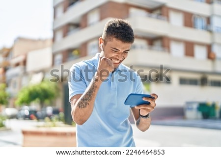African american man smiling confident playing video game at street