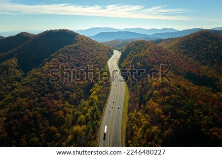 View from above of I-40 freeway in North Carolina heading to Asheville through Appalachian mountains in golden fall season with fast driving trucks and cars. Interstate transportation concept Royalty-Free Stock Photo #2246480227