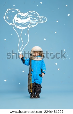 Creative design with drawn elements. Portrait of little boy, child in costume of astronaut over blue background. Planet doodles. Concept of imagination, childhood, creativity, dreams, ad
