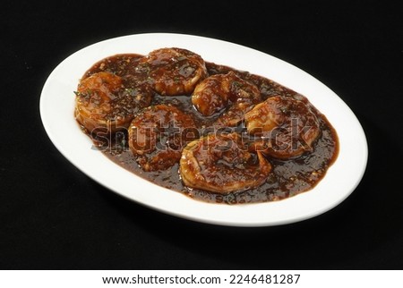 This Prawn (Shrimp) Manchurian is a popular Indo-Chinese delicacy all over India. Battered shrimps, Chinese cuisine pictures, isolated on Black background.