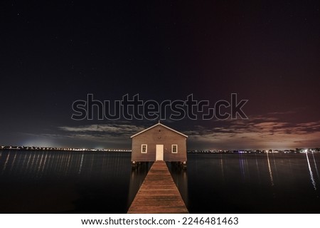 Panoramic view from the jetty of a lakehouse with the cityscape in the background at night