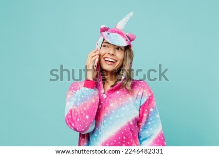 Young woman wear domestic costume with hoody and animals ears talk speak on mobile cell phone conduct pleasant conversation isolated on plain pastel light blue cyan background People lifestyle concept