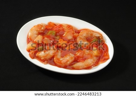 This Prawn (Shrimp) Sweet and Sour is a popular Indo-Chinese delicacy all over India. Battered shrimps, Chinese cuisine pictures, isolated on Black background.