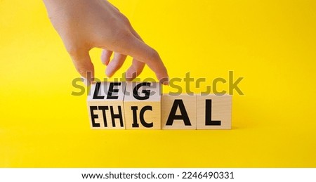 Ethical and Legal symbol. Businessman hand turnes wooden cubes and changes word Ethical to Legal. Beautiful yellow background. Business and Ethical and Legal concept. Copy space