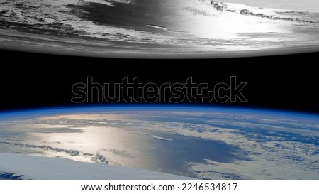 A parallel view of two worlds, one black and white and the other colorful."Elements of this Image Furnished by NASA" Royalty-Free Stock Photo #2246534817