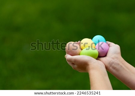 Hands holding colored dyed Easter eggs with a shallow depth of field and copy space
