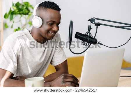 Young creative male african podcaster making live radio podcast from home studio