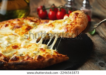 A slice of hot Italian pizza with stretching cheese. Pizza four cheeses with basil. Royalty-Free Stock Photo #2246561873