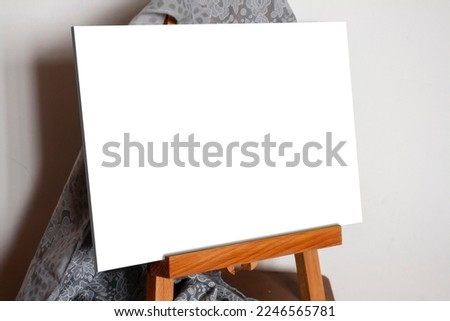 Blank horizontal picture without frame on little easel. Place to insert a picture