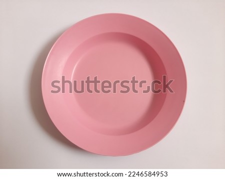 Top view empty plastic pink plate on isolated white background