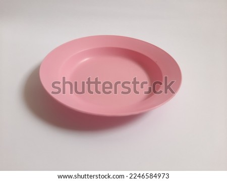 Empty plastic pink plate on isolated white background