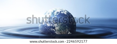 Water, planet and climate change with the earth in a puddle as a symbol of global warming or temperature shift. Nature, abstract and background with the world in the sea or ocean for sustainability