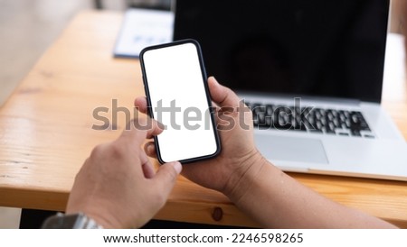 Mockup image of woman holding smartphone with blank white screen at home