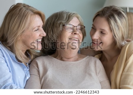 Happy joyful relative women of different ages, generations meeting at home, talking, chatting, laughing, hugging with love, tenderness. United family portrait of elderly grandma, mom, adult grandkid