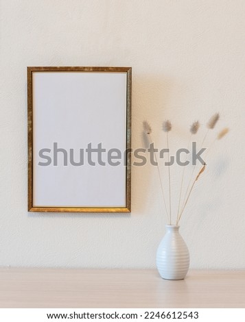 Template with photo frame on a wooden table. Bouquet of Lagurus.