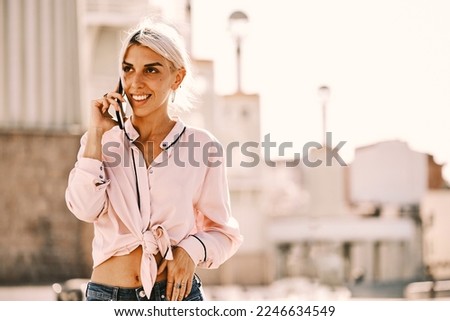 Woman talking on the phone outdoors on the street.