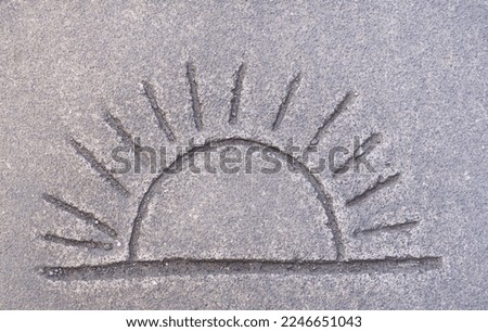 Simple child like drawing of sunshine symbol imprinted in concrete pavement background texture