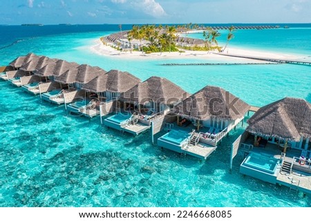 Nice tranquil Maldives island, luxury over water villas resort aerial view. Beautiful sunny sky. Sea bay lagoon beach background. Summer vacation holiday. Paradise shore exotic landscape pristine blue Royalty-Free Stock Photo #2246668085