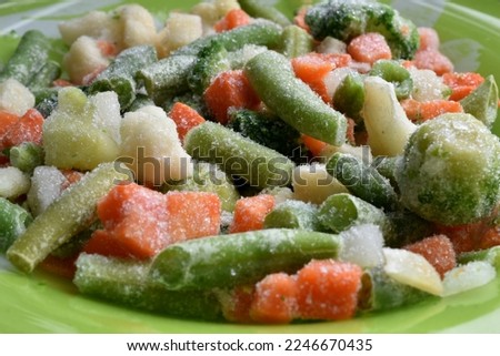 The picture shows fresh frozen vegetables such as broccoli, cauliflower, carrots, which are on a plate.
