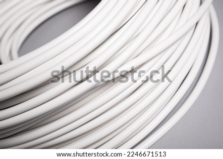 Roll of white electric cable wire on grey background Royalty-Free Stock Photo #2246671513