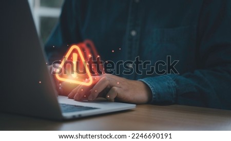 Businessman using computer laptop with red triangle caution warning sign for notification error and maintenance support concept.