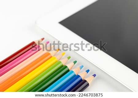 Tablet and colored pencils. An image of creating an illustration with a tablet