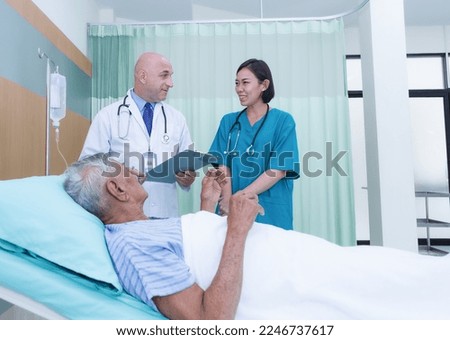 Young female doctors and nurses help to talk to happy elderly male patients giving consultations in the hospital. Caring, encouraging, and comforting mature men. health care concept
