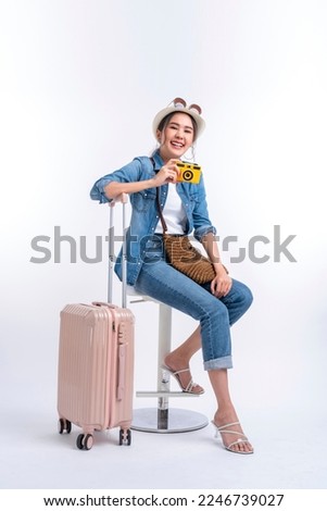 ready to travel ,young teen asian smiling cheerful female woman casual cloth hand hold camera standing with luggage case bag prepare to new abroad journey travel studio shot on white background  Royalty-Free Stock Photo #2246739027