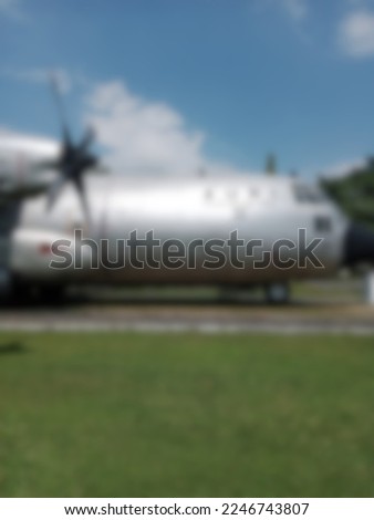 Blur photo of a cargo plane on a green grass runway on a sunny morning.  perfect for an airplane theme
