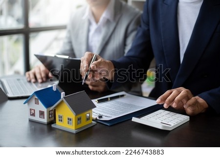 Real estate broker agent presenting and consult to customer to decision making sign insurance form agreement, home model, concerning mortgage loan offer in office
 Royalty-Free Stock Photo #2246743883