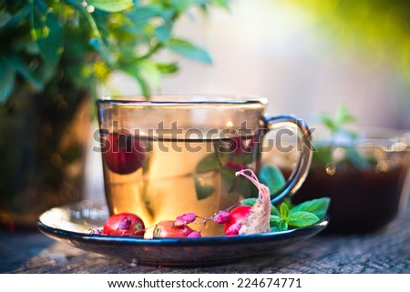 Autumn tea in black glass cup on old grey rustic wooden table