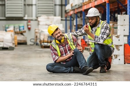 Professional male worker help his colleague after getting accident, injured leg while working in factory or warehouse. Safety, Industry, Healthcare, Insurance Concept