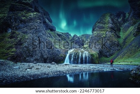 Icelandic Landscape. Scenic image of fairy-tale Stjornarfoss waterfall with Green northern lights. Iconic location for landscape photographers. Iceland, Europe. Incredible vivid landscape of Iceland.