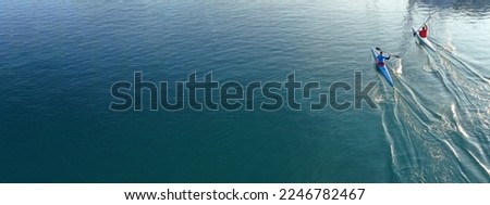 Aerial drone ultra wide slow shutter panoramic photo woth copy space of athletes competing in sport canoe race in tropical lake with emerald waters Royalty-Free Stock Photo #2246782467