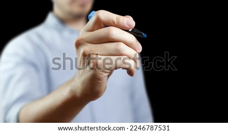 Marker in male hand, isolated on black background