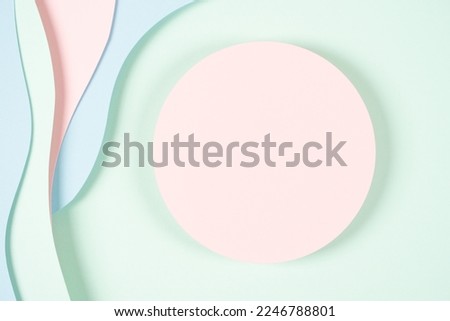 Blank pink round geometric shape podium platform on paper cut abstract geometric shape pastel pink, blue and green background. Top view mock up for product display