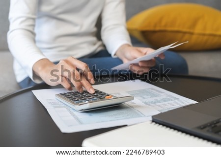 Deduction planning concept. Asian young woman hand using calculator to calculating balance prepare tax reduction income, cost budget expenses for pay money form personal Individual Income Tax Return. Royalty-Free Stock Photo #2246789403