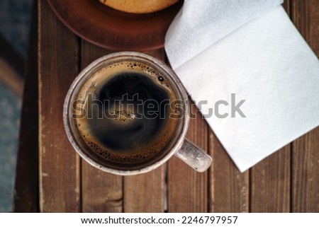 top view shot of a coffee cup, napkin and plate with snack Royalty-Free Stock Photo #2246797957