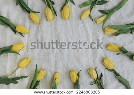 Flowers composition. Wreath made of yellow tulip flowers on neutral grey linen blanket. Flat lay, top view, copy space. Aesthetic Valentine's Day, Mother's Day mockup template