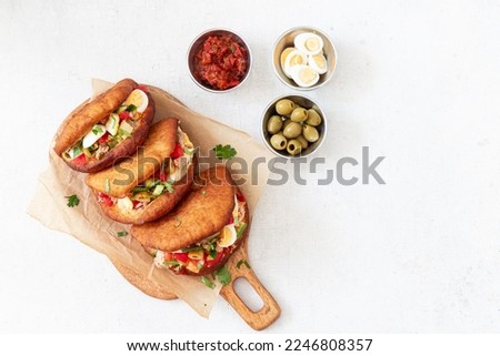 Fricasse is a savory donut filled tuna, potato,boiled egg, olives and harissa.Traditional Tunisian food	
 Royalty-Free Stock Photo #2246808357
