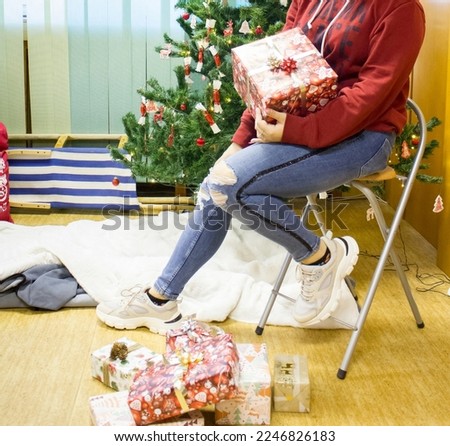 Girl with a gift in a box near the Christmas tree