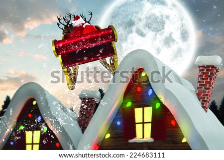 Santa flying his sleigh against cute christmas village