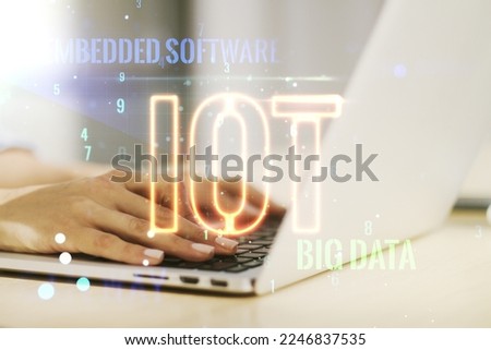Creative IOT hologram with hands typing on computer keyboard on background, internet of things concept. Multiexposure