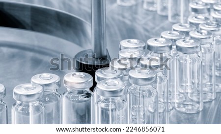 Pharmaceutical industry. Production line machine conveyor with glass bottles ampoules at factory. Pharmaceutical industry concept background. Royalty-Free Stock Photo #2246856071