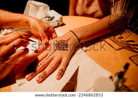 woman painting her hands with ancient ethnic designs