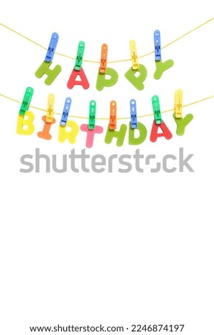 Inscription happy birthday in multi colored letters is hung by clothespins like a garland